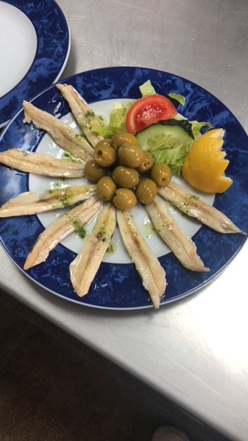 un plato de pescado con olivas